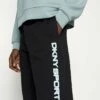 DKNY LAYERED SHADOW LOGO HIGH RISE JOGGER - Tracksuit Bottoms - Black -Bag Haven Store ed7097289e564b7a93b2cbf819187d4d